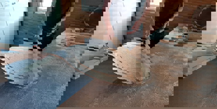 Bilden visar ett tunnbröd som läggs upp på laggen för att gräddas.